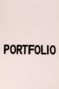 Black letters spelling 'PORTFOLIO' on a light pink background in a minimalist design.