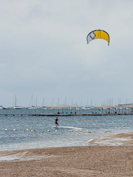 Thrilling kitesurfing at Santiago de la Ribera with sailboats in the background.